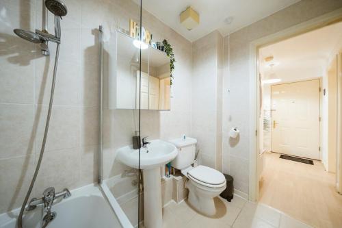 a bathroom with a toilet and a sink and a shower at Cosy 2 BDR flat 5 min to ExCel free Car Parking in London