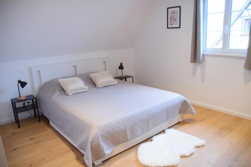a bedroom with a white bed with two pillows at Chambres d'hôtes "La Petite Vallée" in Rott