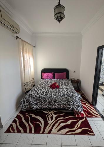 Un dormitorio con una cama con un edredón blanco y negro. en Almohafidon room, en Marrakech