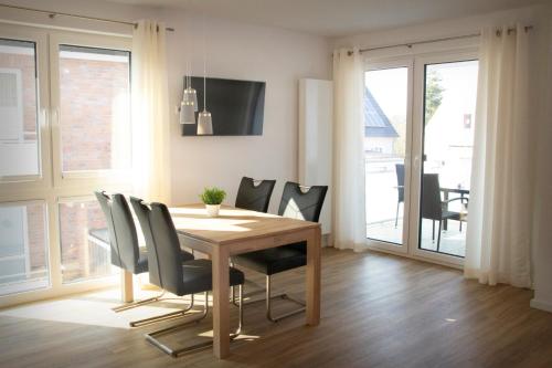 a dining room with a wooden table and chairs at FeWo Dünenquartier Cuxhaven - ideal für Familien und Paare in Cuxhaven