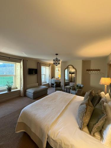 a large bedroom with a large bed and a living room at The Red Lion Inn Alnmouth in Alnmouth