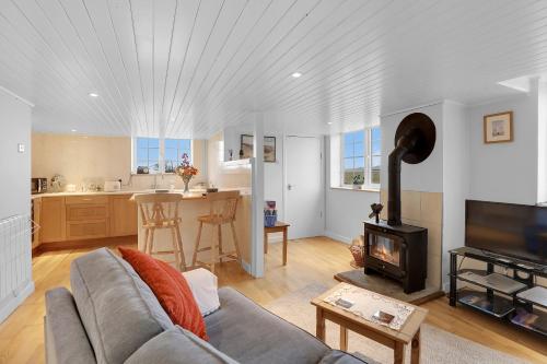 a living room with a couch and a stove at Hill House Hideaway - North East Escapes in Bardon Mill