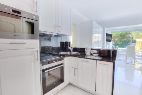 a kitchen with white cabinets and a stove top oven at Windeby 6T in Wenningstedt