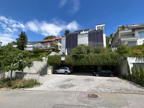 a building with two cars parked in a parking lot at Apartment "Wild Berry" - Business-20 qm-ruhig-Parkplatz-Arbeitsplatz in Leonberg