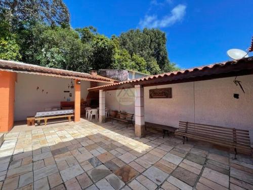 a patio with two benches and a building at CASA DUPLEX Jardim São Lourenço in Bertioga