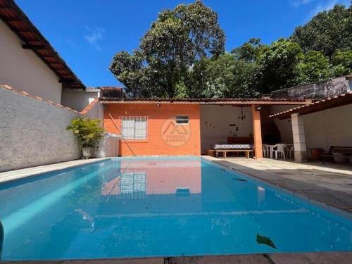 a swimming pool in front of a house at CASA DUPLEX Jardim São Lourenço in Bertioga