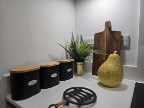 a kitchen counter with a p pear on a stove at Snuggle Inn Serviced Apartments, Great choice for large groups, Contractors, Business Executives and Family Vacations in the stunning valley of Surrey Hills, secure Private Parking, Offering Easy Train Access to London, Gatwick airport, M25 in Warlingham