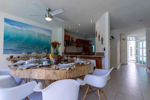 a dining room with a large wooden table and white chairs at Villa en Nuevo Vallarta 15 in Nuevo Vallarta