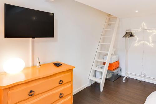 - une chambre avec une commode et une télévision murale dans l'établissement Cannes centre Cosy appartement avec mezzanine, à Cannes