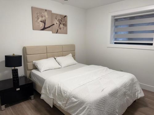 a bedroom with a white bed and a window at Calm & Cozy Private Suite in Surrey