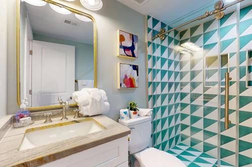 ein Badezimmer mit Waschbecken, Toilette und Spiegel in der Unterkunft Dorsey's Wave On by Meyer Vacation Rentals in Fort Morgan