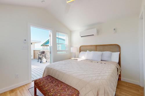 ein Schlafzimmer mit einem großen Bett und einem Balkon in der Unterkunft Dorsey's Wave On by Meyer Vacation Rentals in Fort Morgan