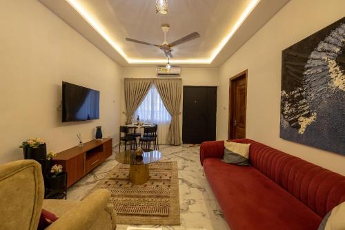 a living room with a red couch and a table at Caros Villa in Adentan