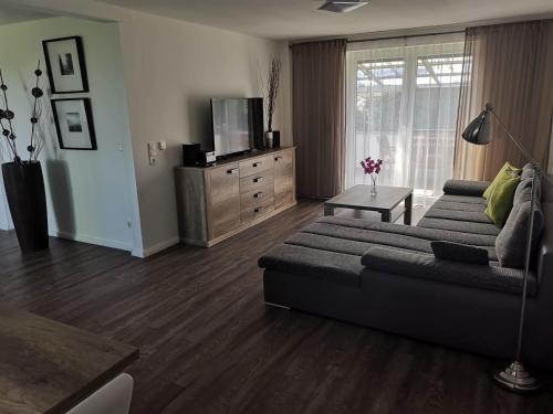 Una sala de estar con un sofá y un televisor. en FeWo Urbaniak Waddens, en Butjadingen