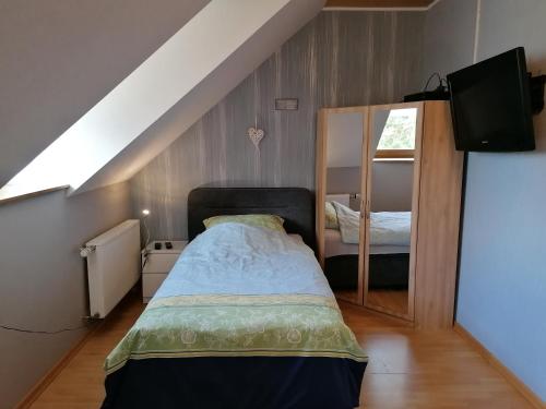 a small bedroom with a bed and a mirror at Knoofs in Schwirzheim