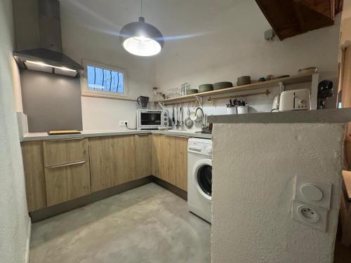 une petite cuisine avec un lave-linge et un sèche-linge. dans l'établissement El Niu - Perpignan hyper centre, à Perpignan