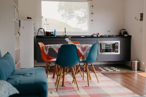 a kitchen with a table and four chairs at Refugio Marincek - Gonçalves - MG in Gonçalves