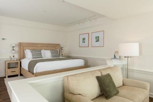 a bedroom with a bed and a chair and a couch at Outlook Inn on Orcas Island in Eastsound