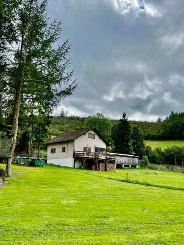 a house in the middle of a field with a train at Blockhaus Ourtal in Winterspelt