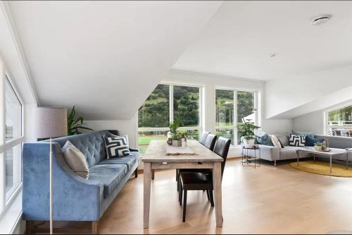 a living room with a blue couch and a table at 4 roms leilighet ved Fosshaugane Campus in Sogndal