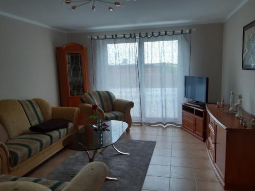 a living room with a couch and a tv at Ferienwohnung in Gresenhorst