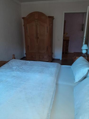 a bedroom with a large bed and a wooden cabinet at Ferienwohnung Bergblick in Hallenberg