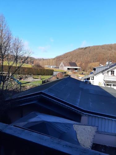 a black roof on a house with a mountain in the background at Ferienwohnung Bergblick in Hallenberg
