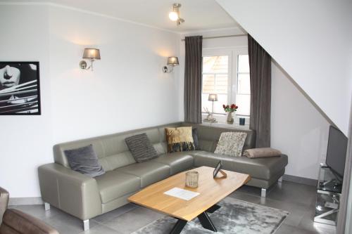 a living room with a couch and a table at Seeblick 8 - Luxus direkt am Hafen von Norddeich in Norddeich
