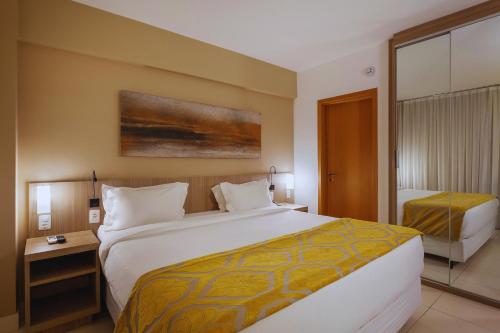 a hotel room with a large white bed and a bed sqor at Quality Hotel Pampulha & Convention Center in Belo Horizonte
