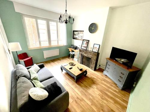 a living room with a couch and a fireplace at Ecrin Historique d 'Amiens Charme & Comfort Central in Amiens