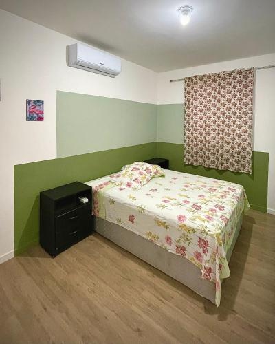 a small bedroom with a bed and a window at Ap de 2 quartos com AR, wifi e garagem - Bairro tranquilo in Santo Ângelo