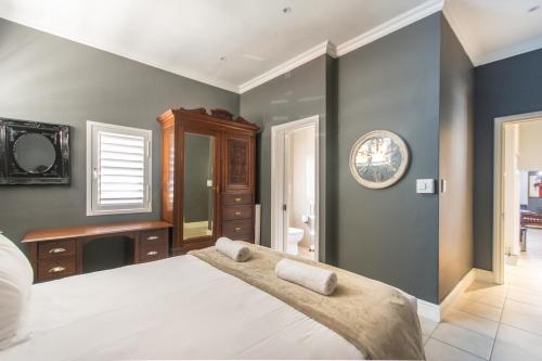 Un dormitorio con una cama grande y un espejo. en Millwood Apartment, en Ciudad del Cabo