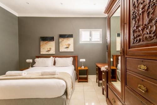 a bedroom with two beds and a dresser at Millwood Apartment in Cape Town