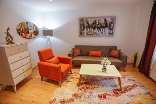 a living room with a couch and a table and a chair at Turis Ferienwohnung 65-4 in Triberg