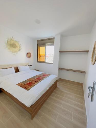 a bedroom with a large bed and a window at Maghrib Nomads Hostel in Tamraght Ouzdar