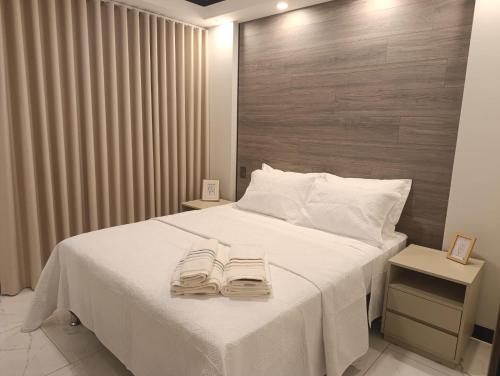 ein Schlafzimmer mit einem weißen Bett mit zwei Handtüchern darauf in der Unterkunft Luxia Sky Deluxe Equipetrol in Santa Cruz de la Sierra