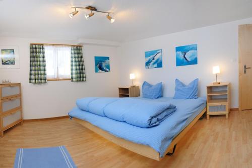 ein Schlafzimmer mit einem großen Bett mit blauer Bettwäsche in der Unterkunft Haus Leopold in Zermatt