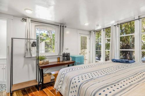 sypialnia z łóżkiem, biurkiem i oknami w obiekcie Jennifers Room - Pet Friendly w mieście Summerland