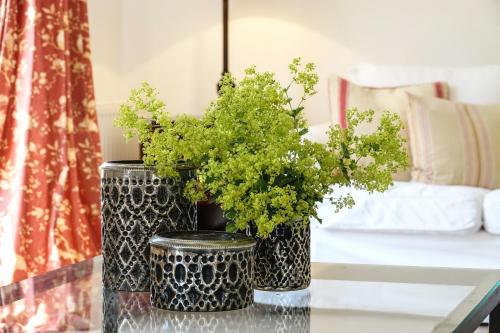 two black and white vases with plants on a table at Michels Huus - Schloss Gelting in Gelting