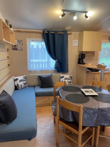 un salon avec un canapé et une table dans l'établissement 600m de la plage - Mobilhome Loka 4 personnes camping Goelands 3 étoiles, à Saint-Martin-Plage