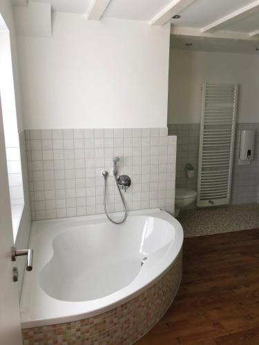 a bath tub with a shower in a bathroom at Ferienloft Dalum in Geeste