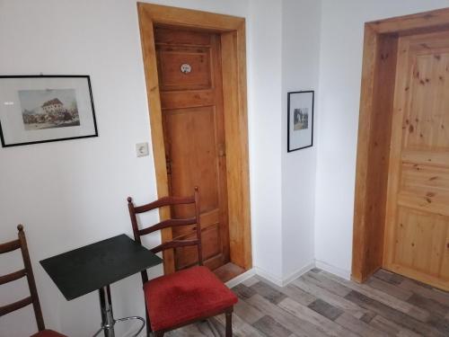 a room with a table and chairs and a door at Ferienwohnung Dolecki Rippach in Lützen