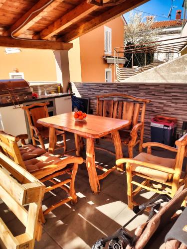 a wooden table and chairs on a patio at Ferienhaus Maja in Pavicini