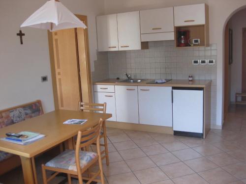a kitchen with a wooden table and a table and chairs at Ferienwohnung im Haus Texel IV in Rablà