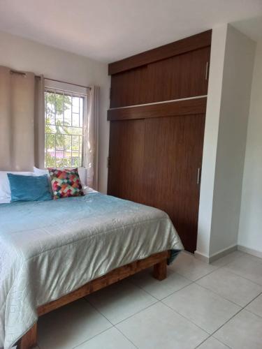 a bedroom with a bed with a wooden wall at Family apartment in excellent location in Tampico