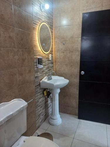 a bathroom with a sink and a toilet and a mirror at Family apartment in excellent location in Tampico