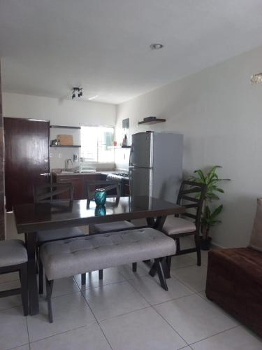 a dining room with a table and chairs and a kitchen at Family apartment in excellent location in Tampico
