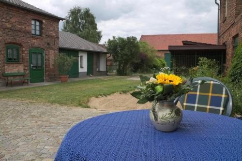 a vase with yellow flowers sitting on a table at Spreewälder Schwalbenhof - Ferienwohnung "Nistkasten" in Golßen