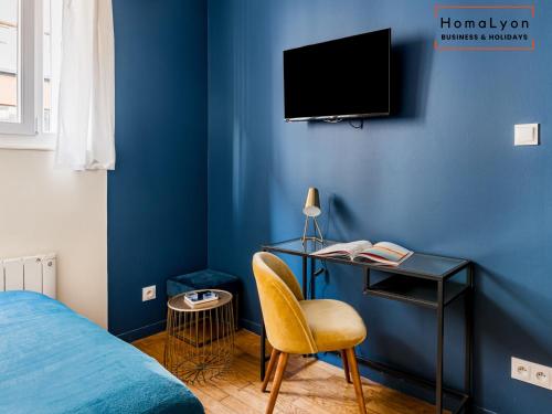 - une chambre dotée d'un mur bleu avec un lit et un bureau dans l'établissement Studios Part-Dieu Gare - HomaLyon, à Lyon