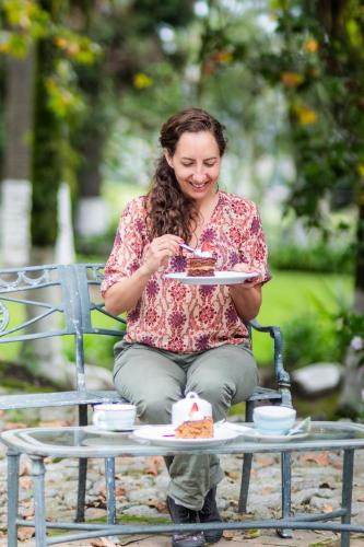 a woman sitting on a bench eating a slice of pizza at Hostería Hacienda Pinsaqui in Otavalo
